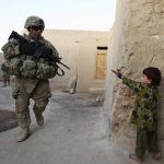 GIRL GESTURES TO U.S. SOLDIER ON PATROL IN AFGHANISTAN IN JUNE